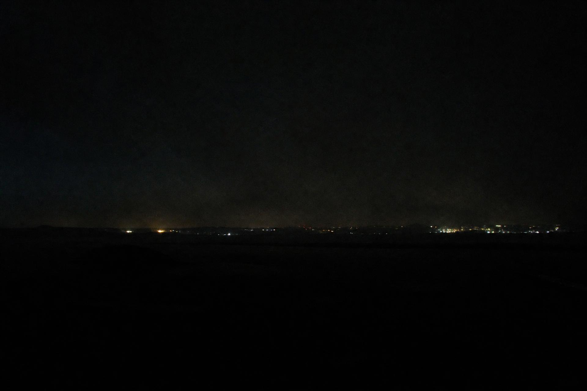 Distant lights along a dark horizon